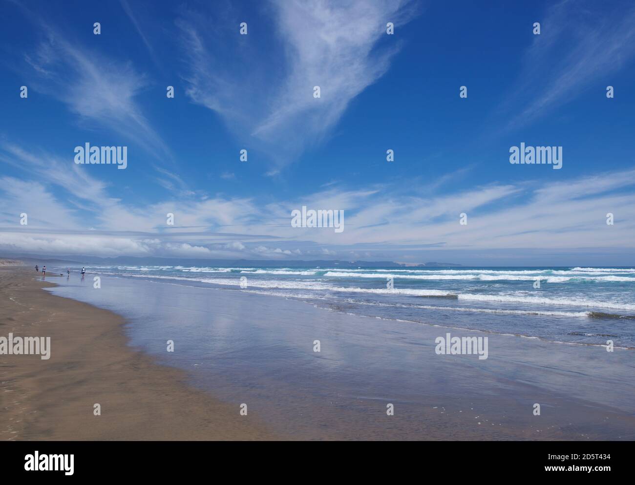 Beautiful panoramic scenic view to the ocean with woman figure in the water. New Zealand Stock Photo