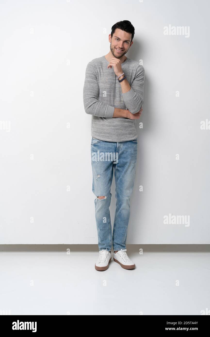 full length of handsome young man on white background looking at camera ...