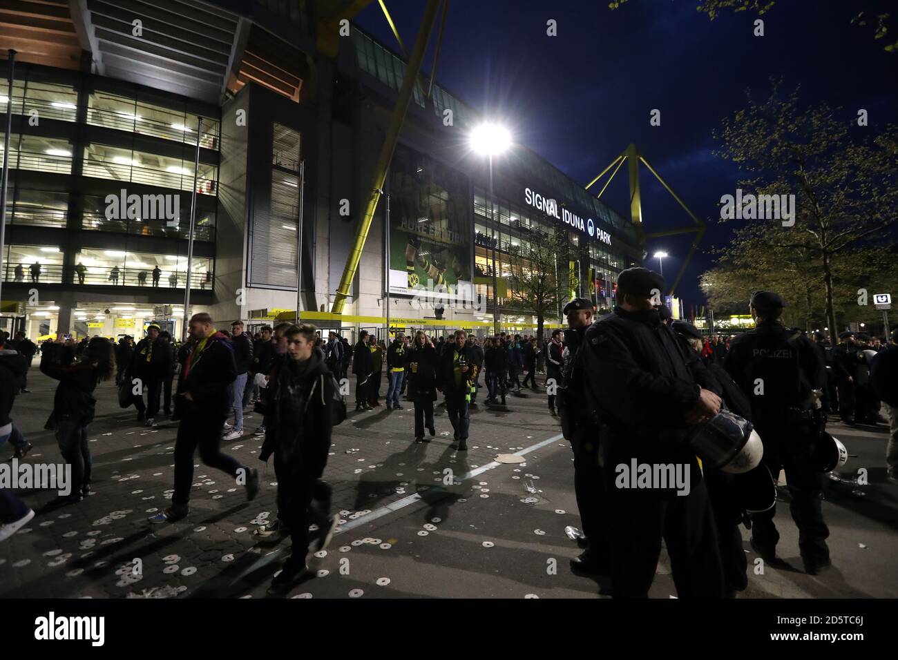 Fans make their way home after the game is postponed following an incident on the team coach Stock Photo