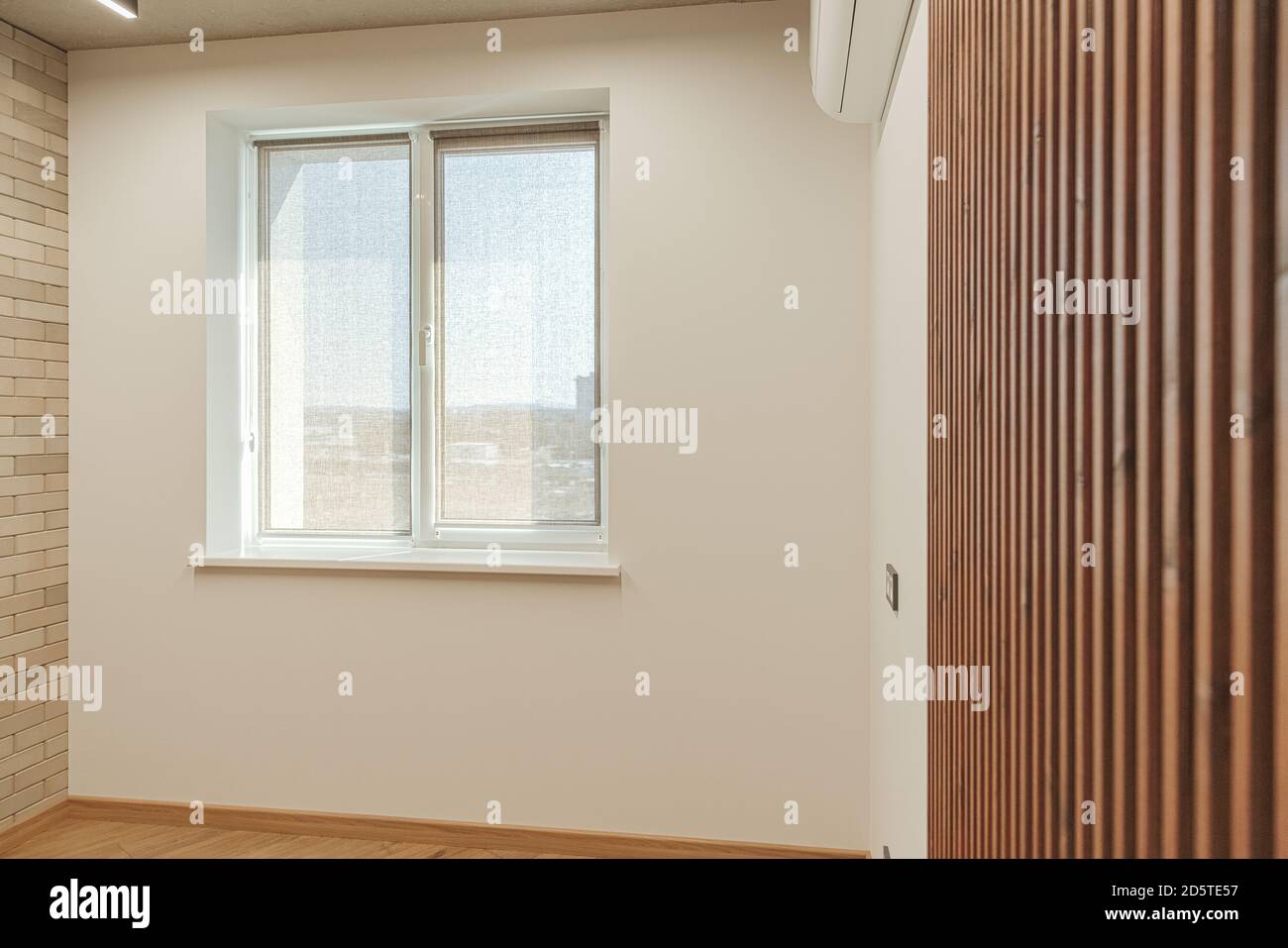 The bright room with a window, decorated with dark brown wooden slats