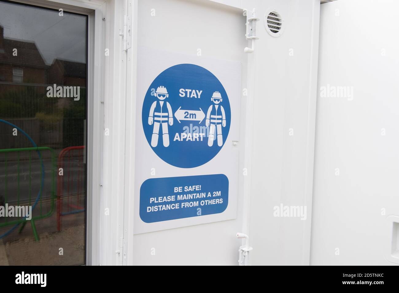 Building construction site Covid-19 safety information sign warning workers to keep social distancing and stay 2mtrs apart. Stock Photo
