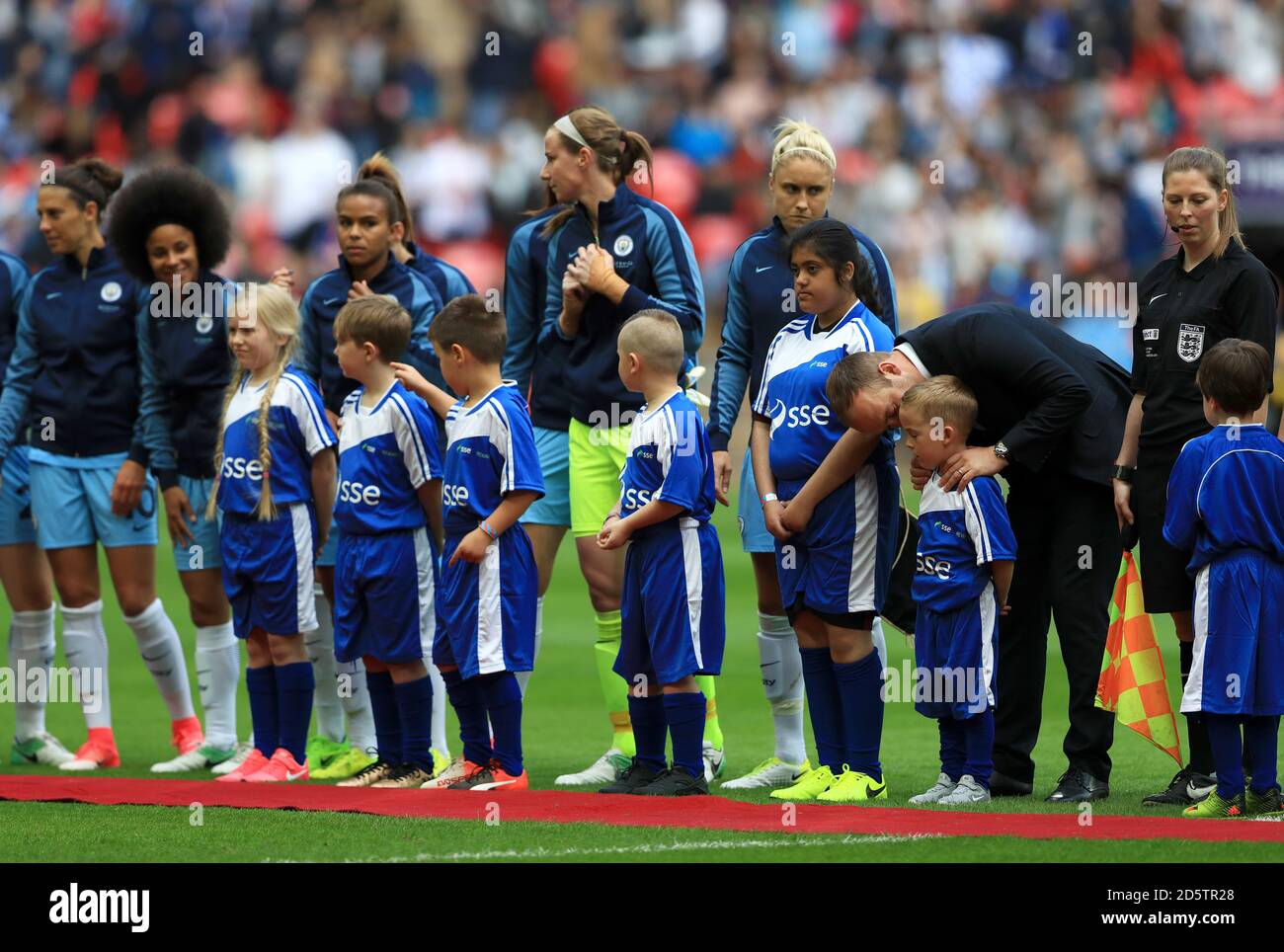 Manchester City manager Nick Cushing and his players with the matchday mascots before the game Stock Photo