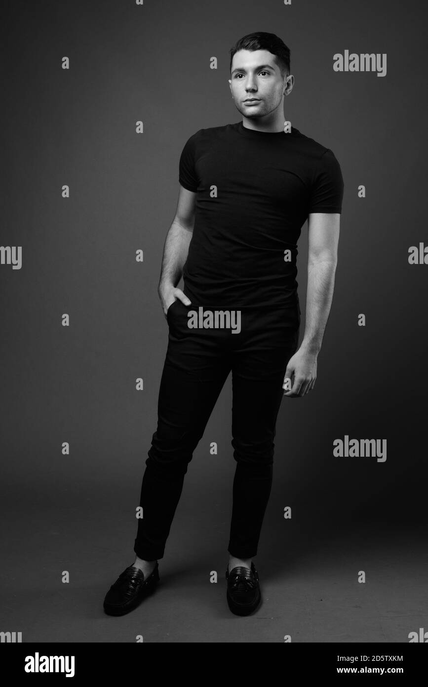 Portrait of young handsome man against gray background Stock Photo - Alamy