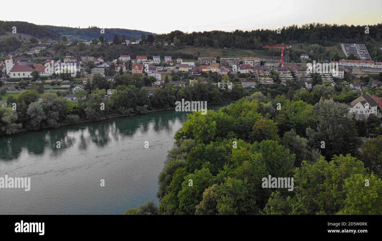 Aerial view over river Aare in riparian forest in Brugg. View to the train bridge and residential area of Umiken and Brugg, Switzerland. Stock Photo