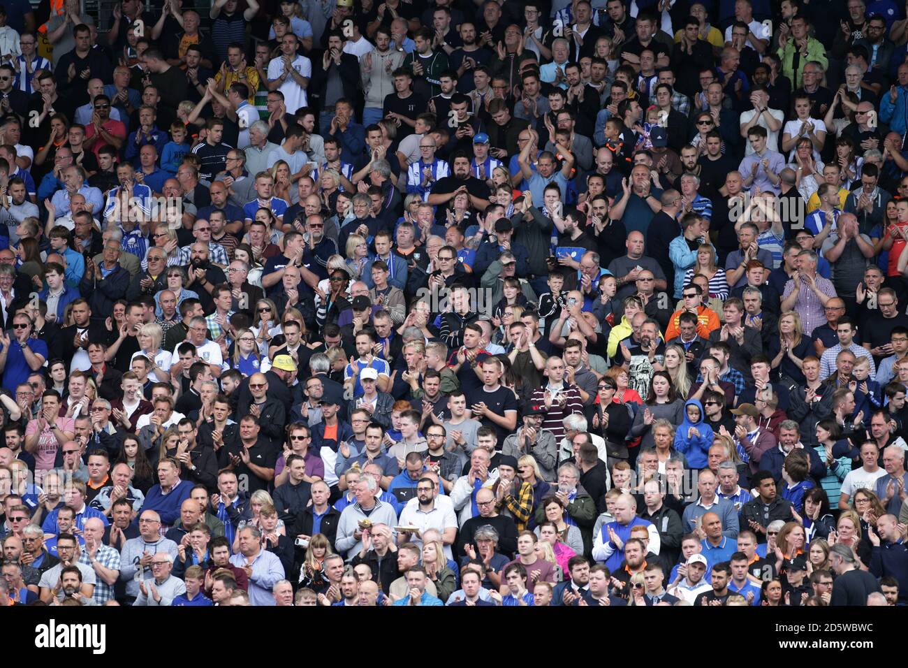 Fans show their support as Fulham and Sheffield Wednesday players observe a minute's applause for the Barcelona attack. Stock Photo