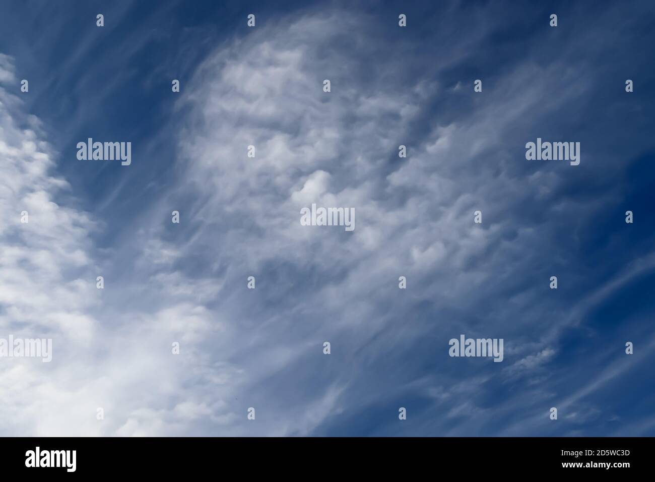 Stunning cirrus cloud formation panorama in a deep blue summer sky seen ...
