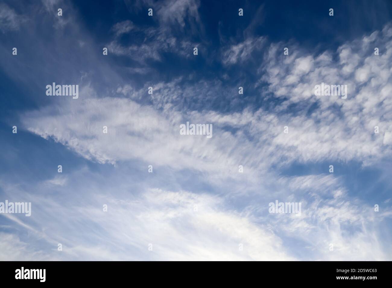 Stunning cirrus cloud formation panorama in a deep blue summer sky seen ...