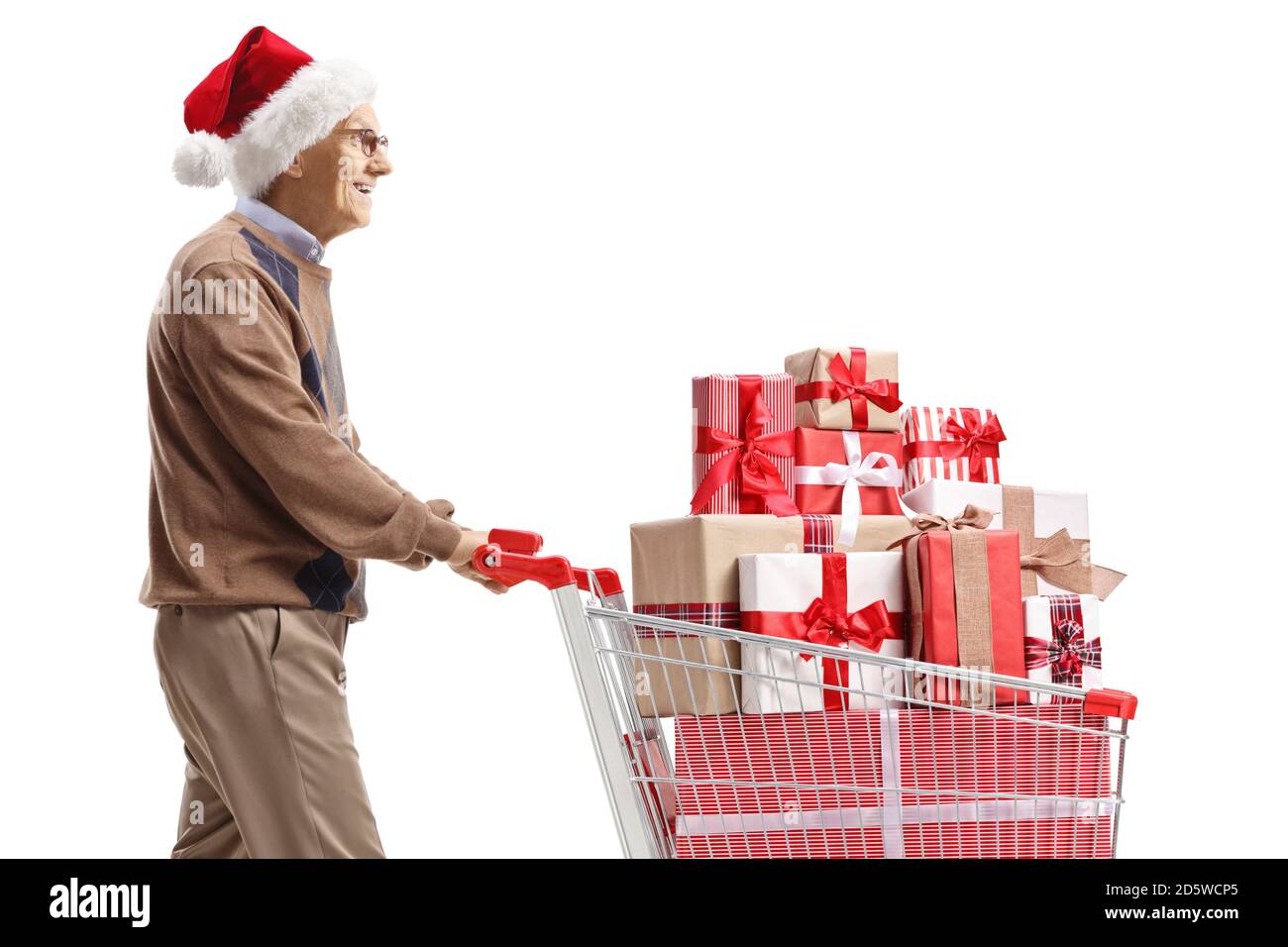 Elderly man with a santa claus hat pushing a shopping cart with christmas presents isolated on white background Stock Photo