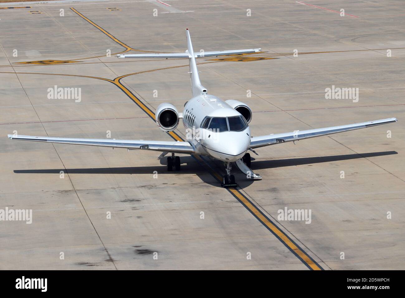 Private jet airplane parked on the taxiway at the airport Stock Photo