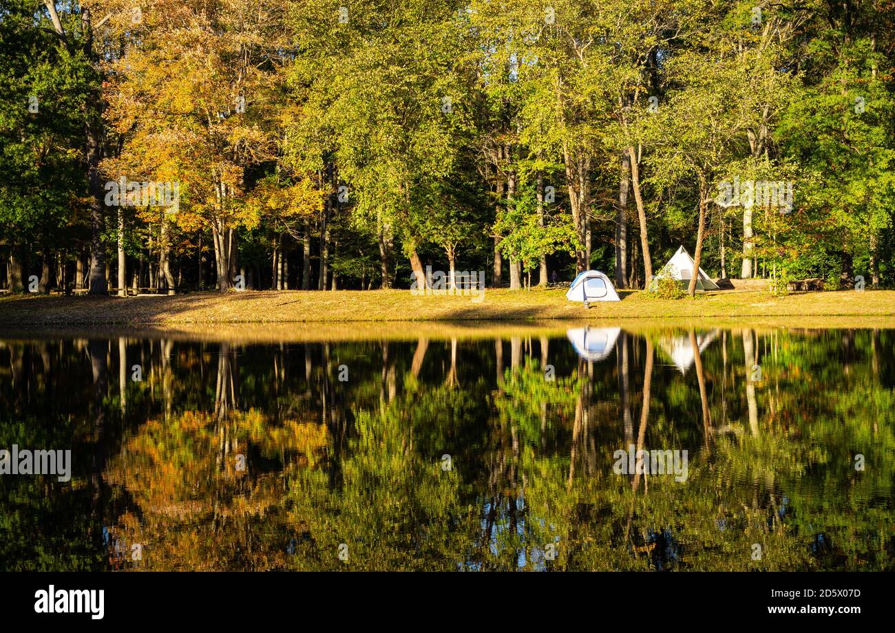 A small tent by a pond on a beautiful late autumn afternoon Stock Photo