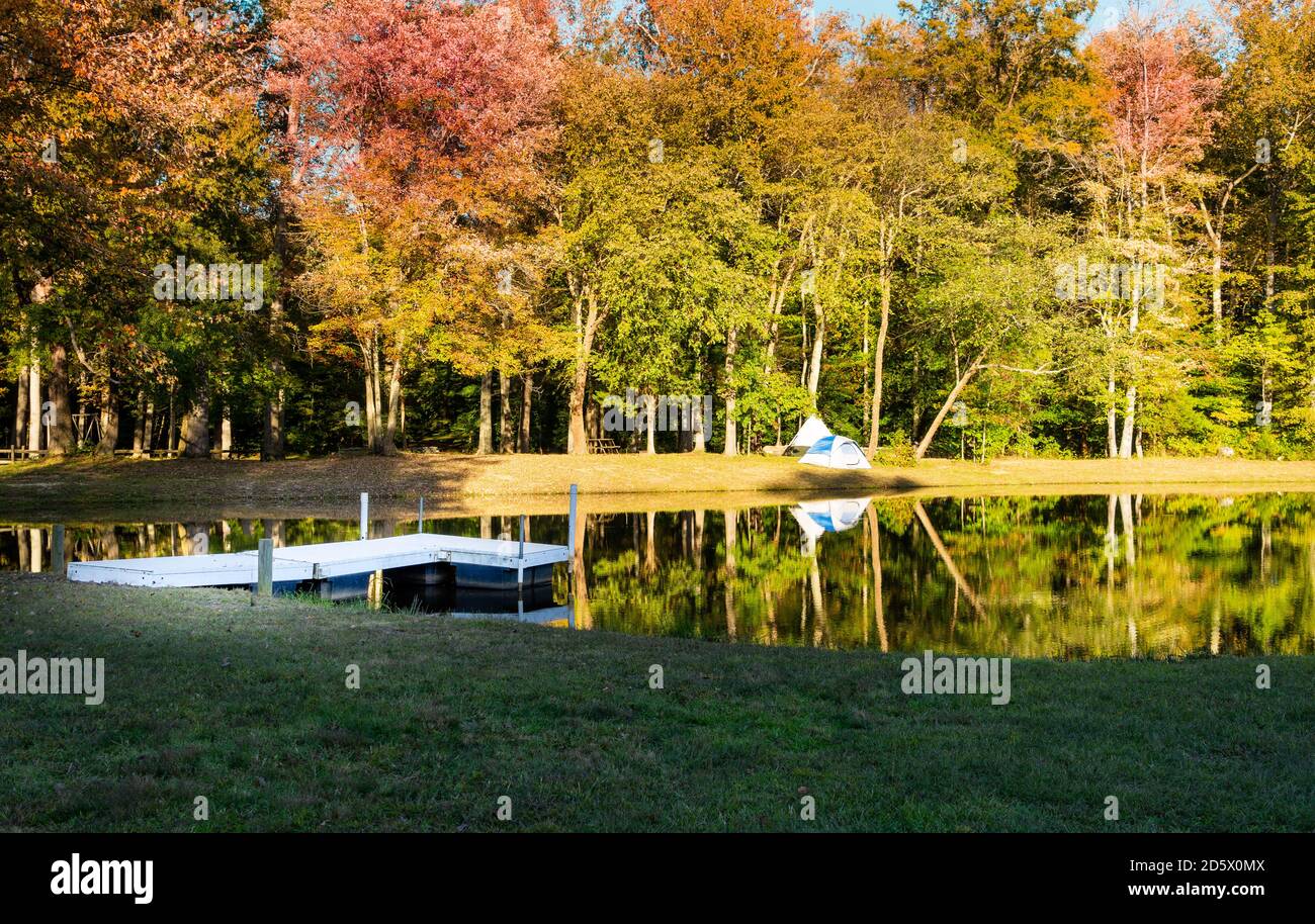 A small tent and wood dock by a small pond on a beautiful autumn afternoon Stock Photo