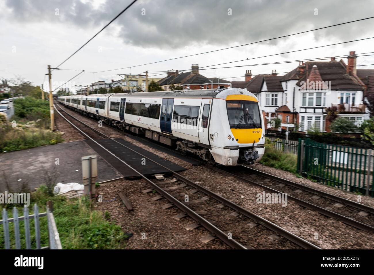 Class 357 Electrostar train on the C2C Fenchurch Street to Southend line at Westcliff on Sea, Essex, UK. Crossing a level crossing at Crowstone Road Stock Photo