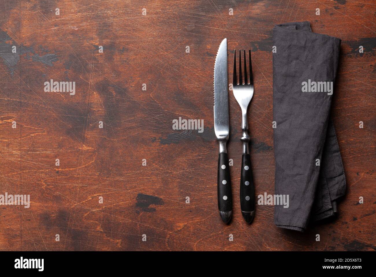 Wooden table with knife and fork. Top view flat lay with copy space