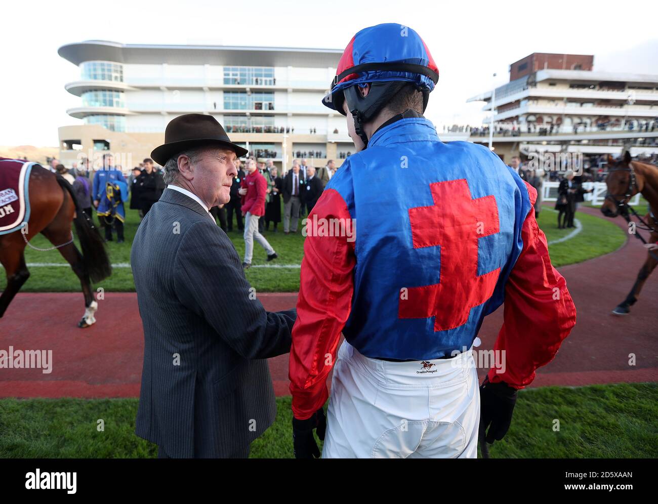 Jonjo O'Neill speaks with his jockey James King before the Joel Dommett Here On 6th April Amateur Riders' Handicap Chase during day one of the Showcase at Cheltenham Racecourse Stock Photo