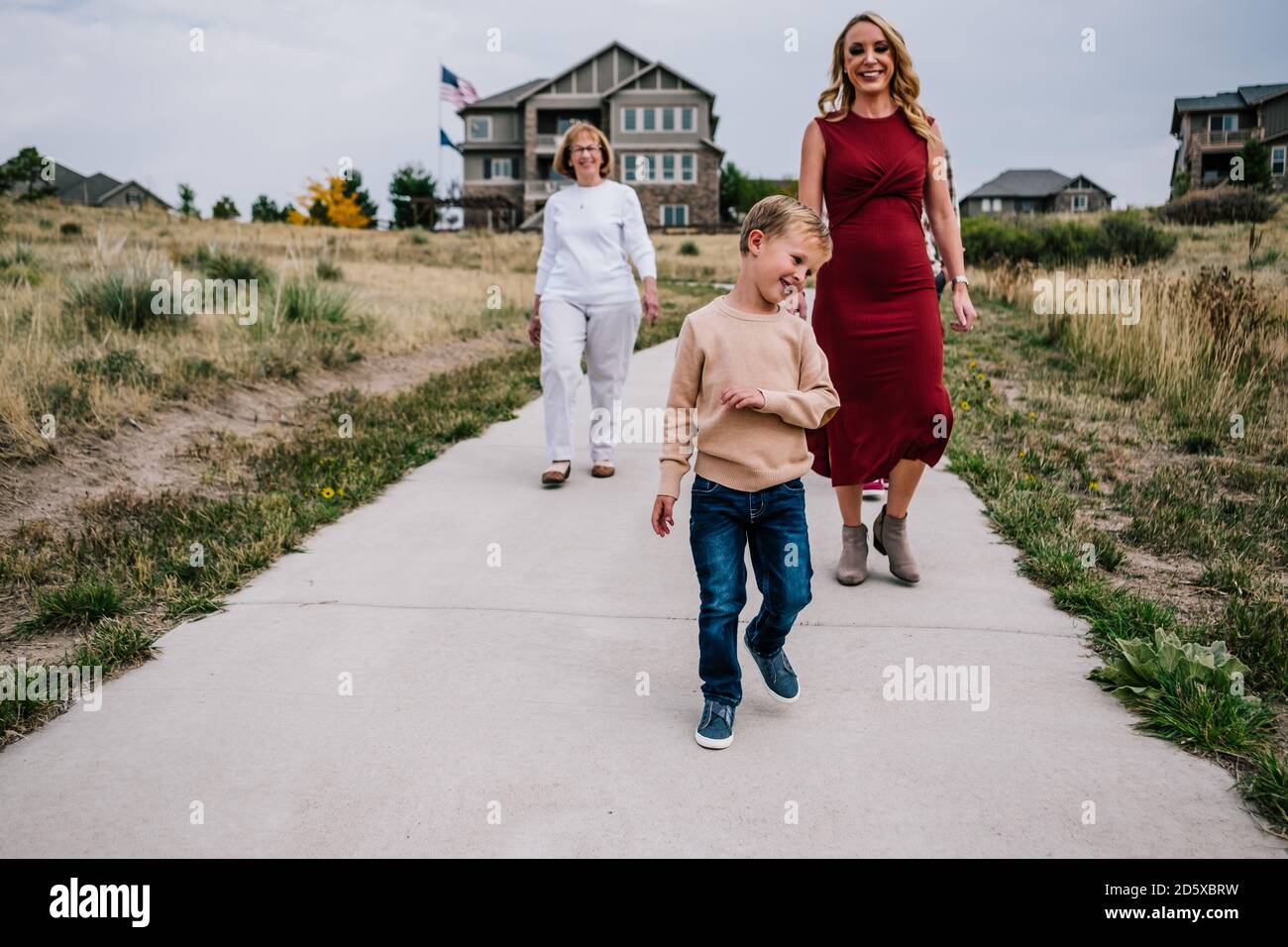 Smiling boy walking with mother and grandmother outside Stock Photo