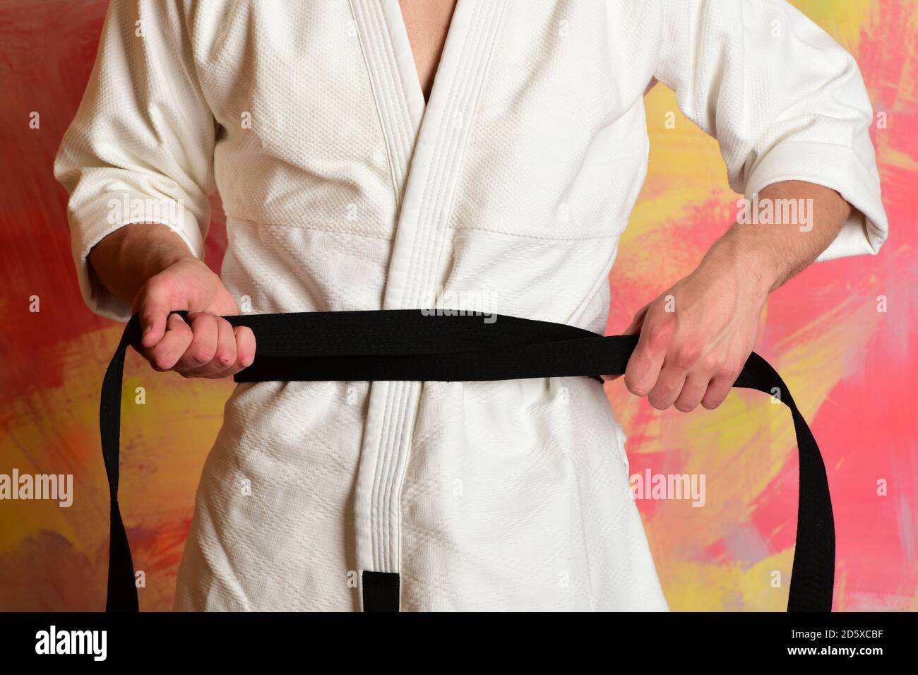 Karate fighter with fit strong hands gets ready to fight. Male body and