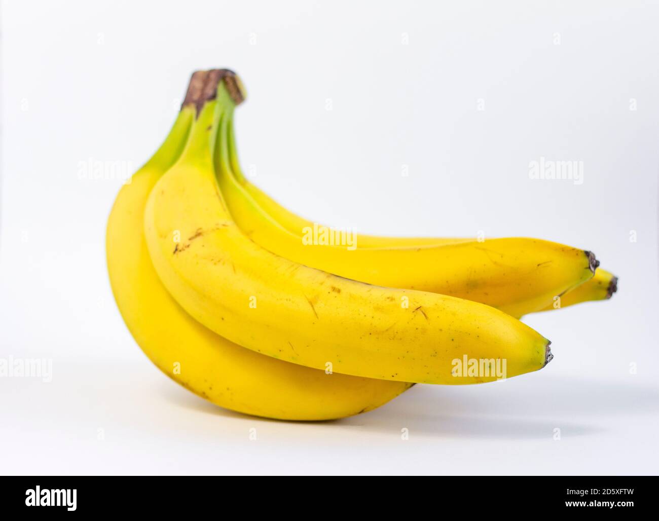 Ripe yellow bananas.A bunch of ripe bananas with dark spots on a white background. Stock Photo