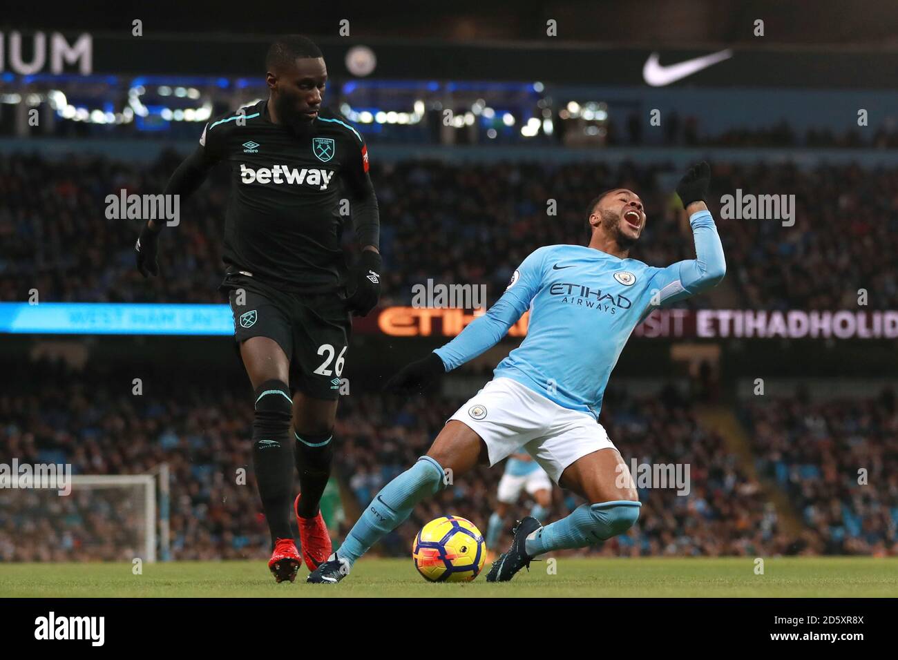 Manchester City's Raheem Sterling (right) goes down in the penalty area after a challenge by West Ham United's Arthur Masuaku but no penalty is awarded  Stock Photo