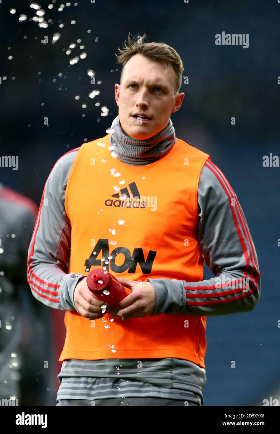 Manchester United's Phil Jones squirts his water bottle on the pitch during the pre-match warm up Stock Photo