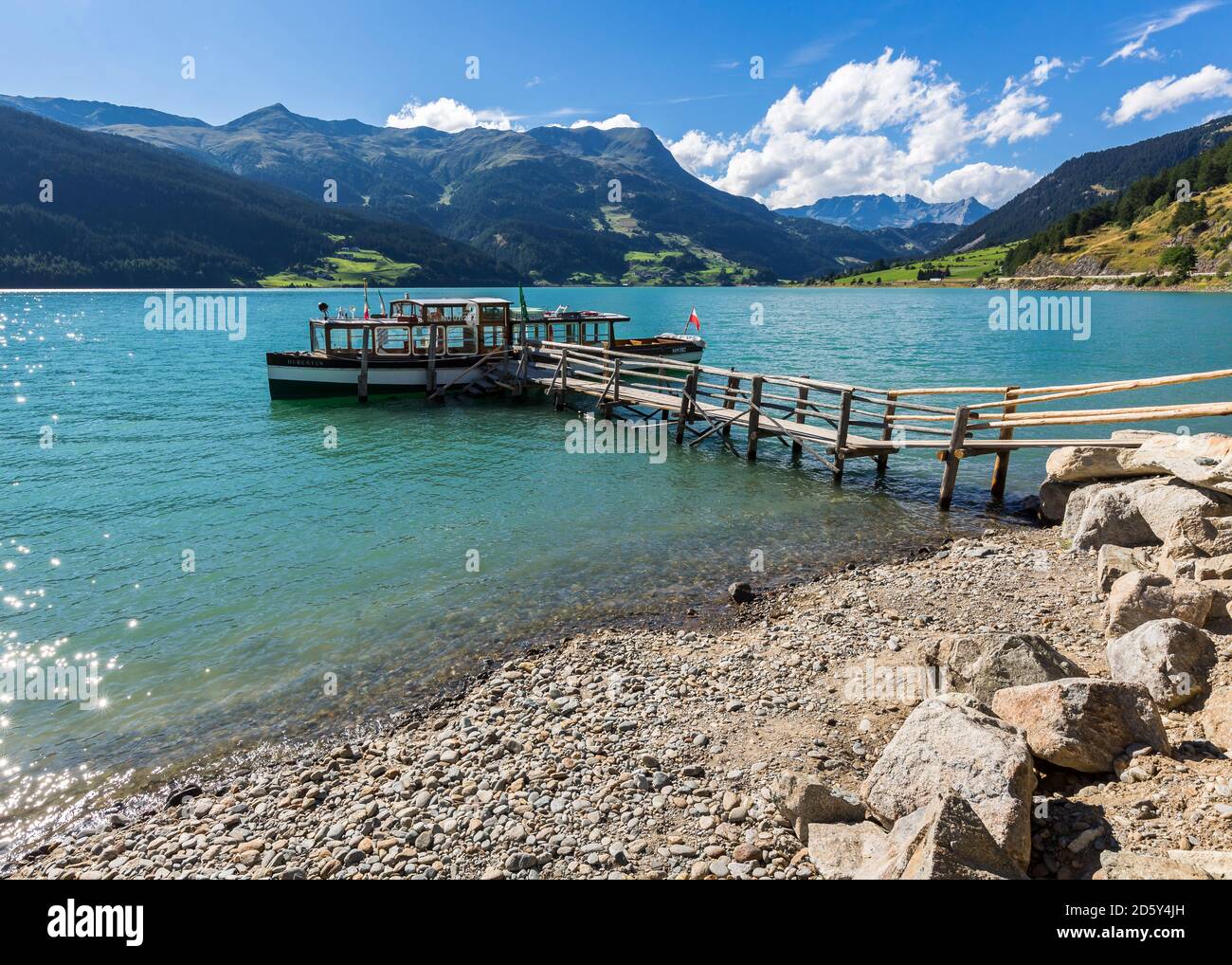 Italy, South Tyrol, Vinschgau Province, Reschensee Lake, boat on jetty Stock Photo