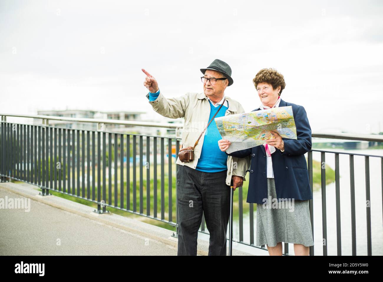 Senior couple with map standing on a bridge Stock Photo