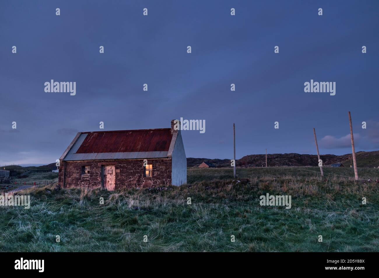 The Clachtoll Salmon Fishing Bothy with Net Drying Posts as Night Falls Over Clachtoll, Assynt, NW Highlands, Scotland, UK Stock Photo