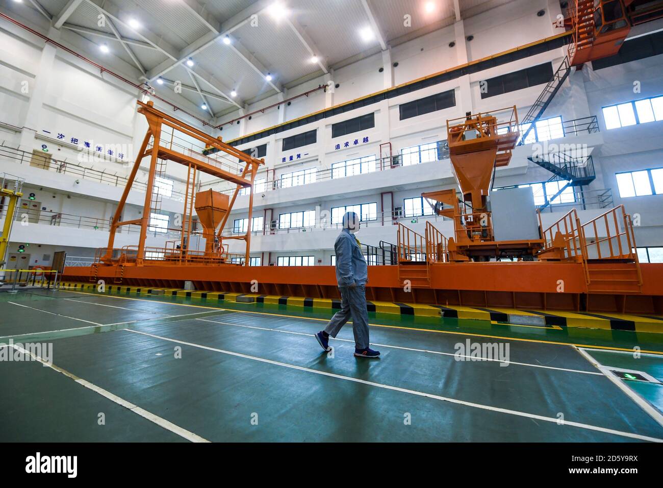 (201014) -- SHENZHEN, Oct. 14, 2020 (Xinhua) -- Qiao Sukai walks past a simulated refueling pool at a training center in Shenzhen, south China's Guangdong Province, April 12, 2019. Every 18 months, the Dayawan Nuclear Power Plant has to undergo a fuel assemblies replacement, which is one of the most important moments for the nuclear power plant. Dozens of engineers are divided into four shifts and operate the equipment day and night when the reactor is shut down. Their leader, Qiao Sukai, has been dealing with nuclear fuel since July 1993 when the nuclear fuel assembly of Dayawan Nuclear Power Stock Photo