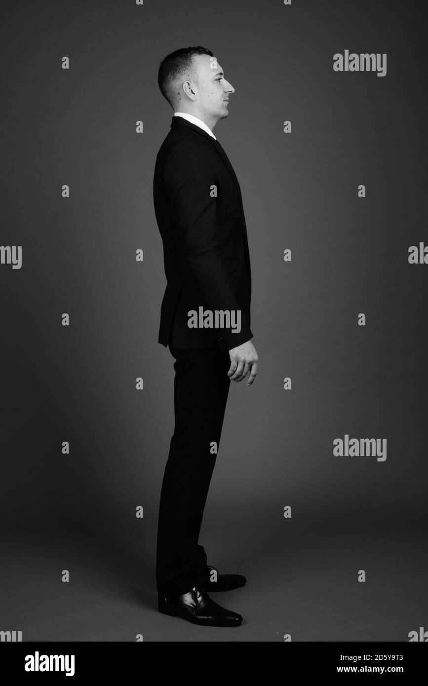 Businessman wearing suit against gray background Stock Photo - Alamy