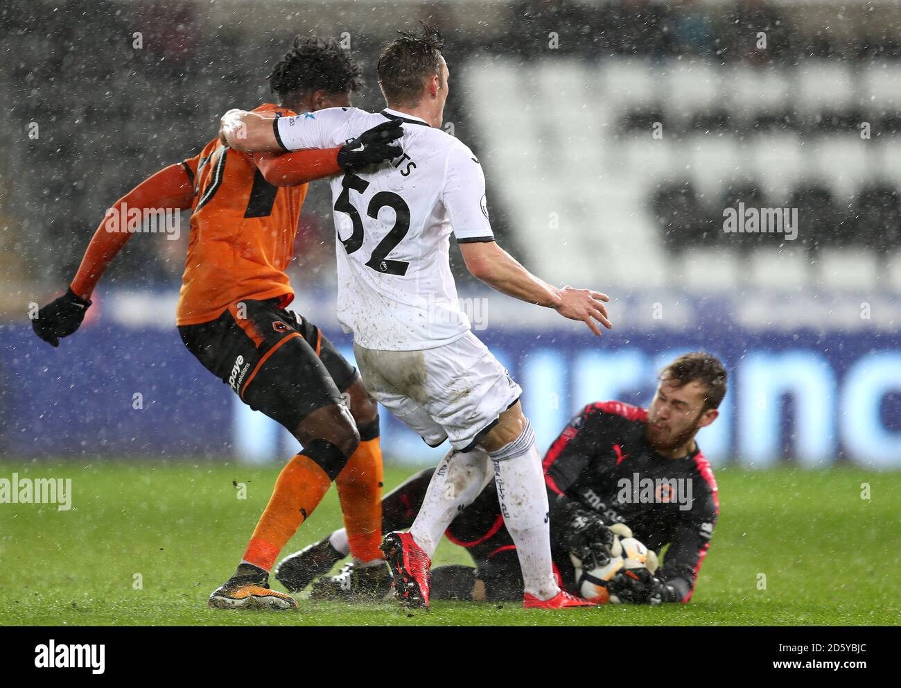 Wolverhampton Wanderers' Kortney Hause (left) battles for the ball with Swansea City's Connor Roberts and Goalkeeper Kristoffer Nordfeldt (right) Stock Photo