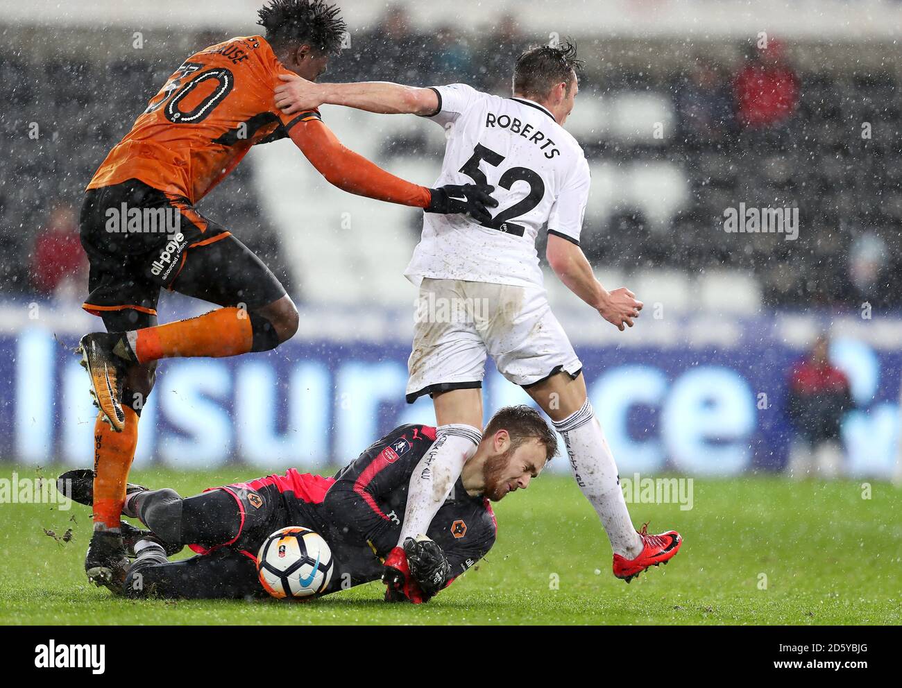 Wolverhampton Wanderers' Kortney Hause (left) battles for the ball with Swansea City's Connor Roberts and Goalkeeper Kristoffer Nordfeldt (centre) Stock Photo