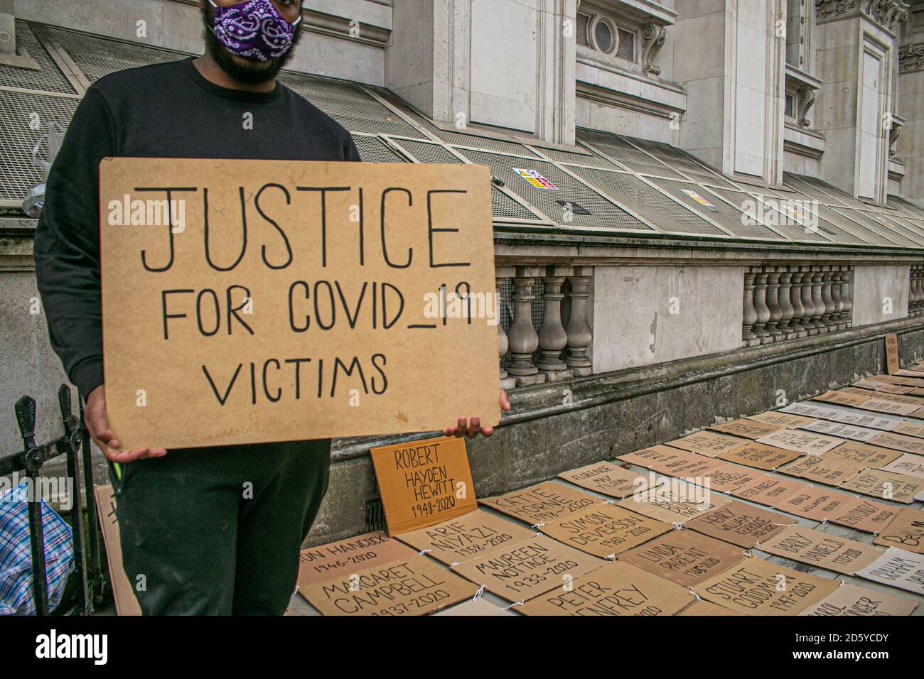 WESTMINSTER LONDON,UK  14 October 2020. A man holds a placards for bereaved relative next to the names of  UK victims of coronavirus covid-19   outside Downing Street seeking 'justice  and to hold the government to account for Covid-19 failings. Credit: amer ghazzal/Alamy Live News Stock Photo