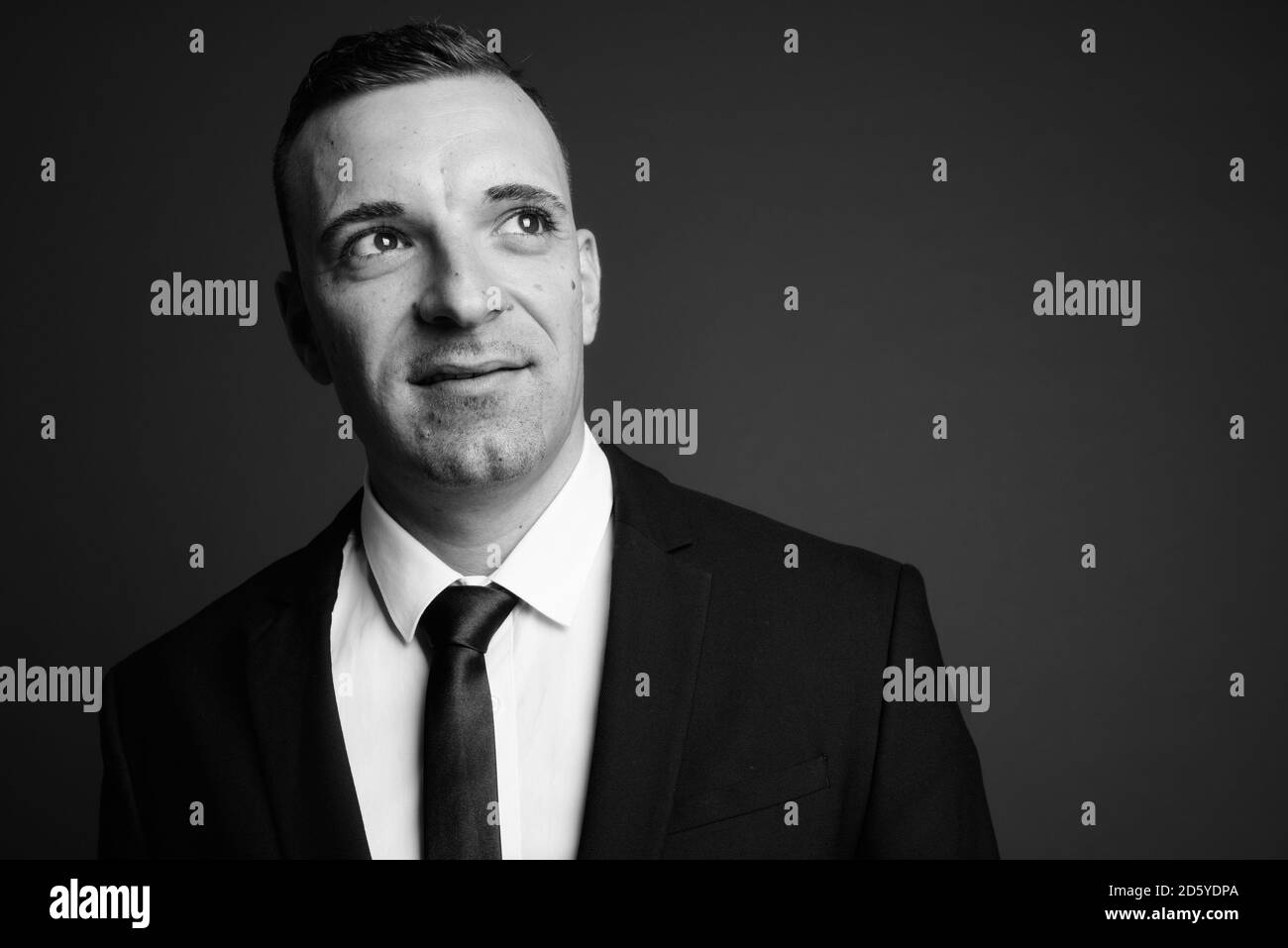 Businessman wearing suit against gray background Stock Photo - Alamy