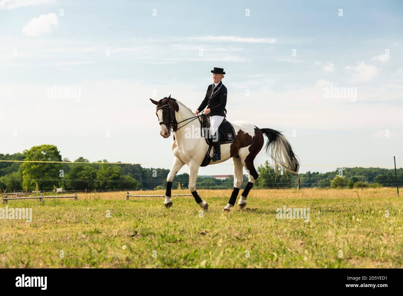 Woman riding horse on a meadow Stock Photo