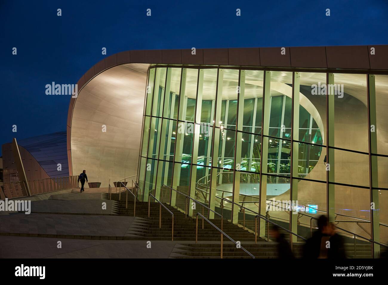 Netherlands, Arnheim, lighted glass facade of central station by night Stock Photo