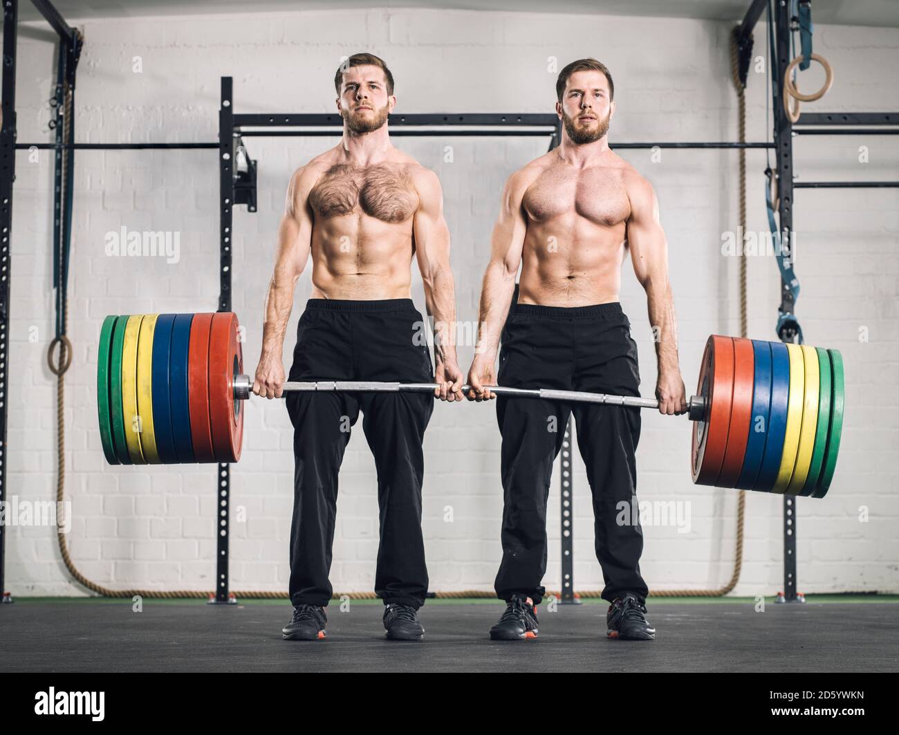 Twin brothers weightlifting in gym Stock Photo - Alamy