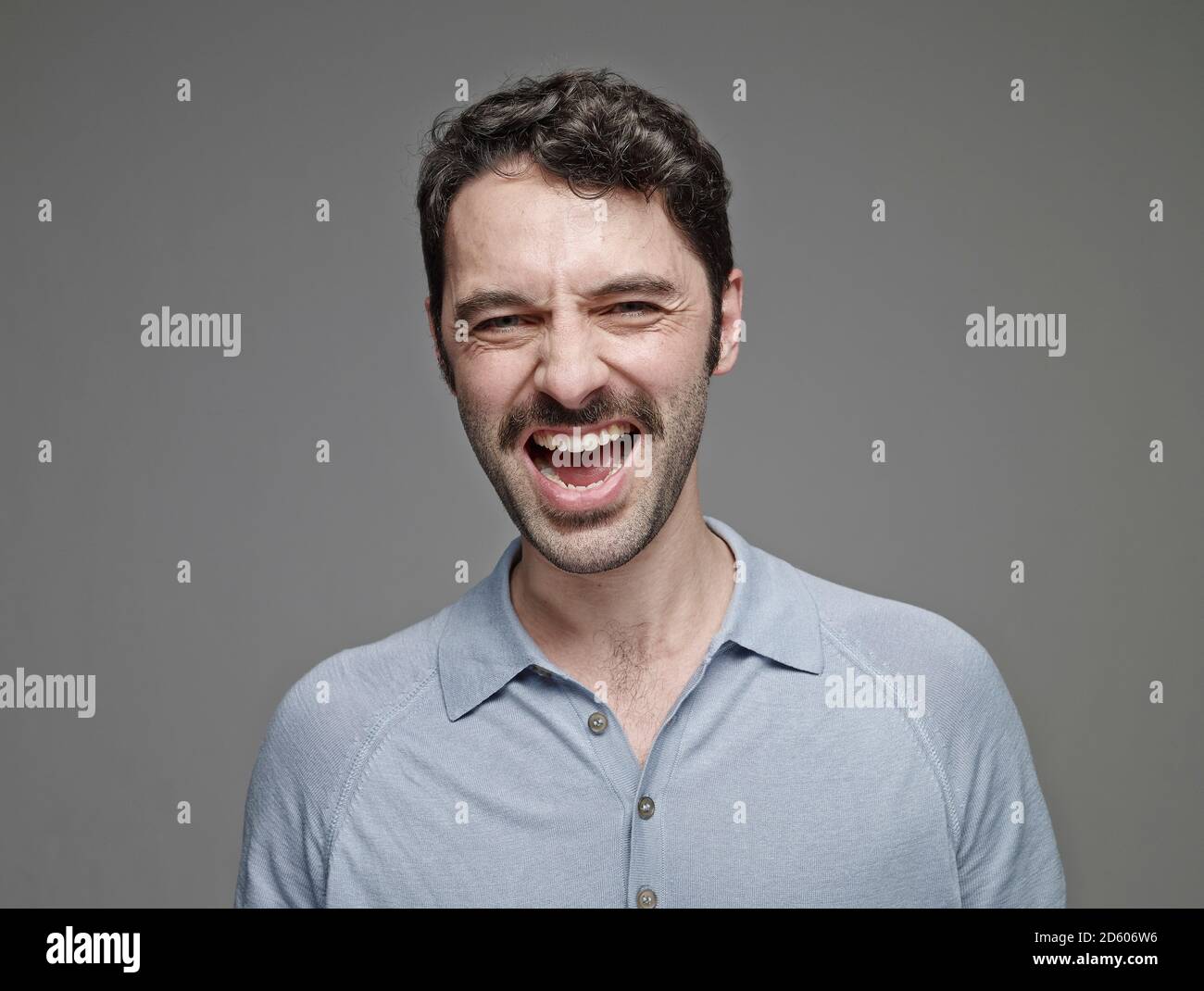 Portrait of screaming man in front of grey background Stock Photo - Alamy