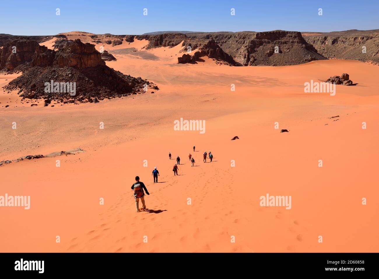 Africa, Algeria, Sahara, Tassili N'Ajjer National Park, Tadrart region, Group of people on sand dune at Oued Bouhadian Stock Photo