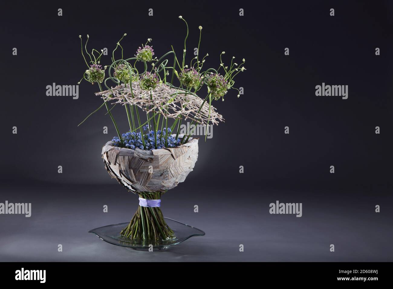Floral arrangement of musa, Poaceae, Allium sativum var. ophioscorodon, Allium scorodoprasum, Myosotis Stock Photo
