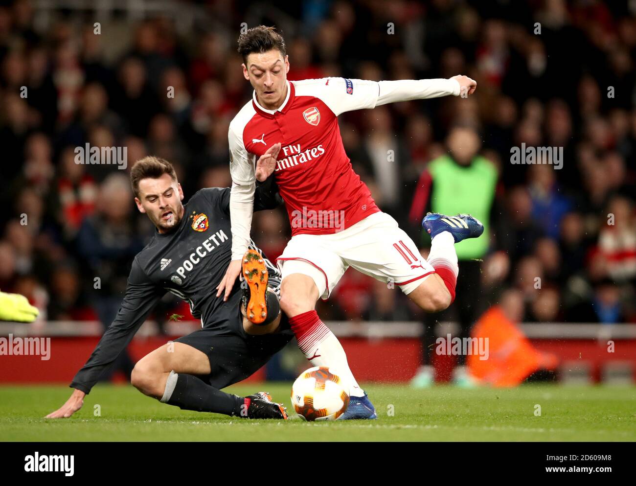 Arsenal's Mesut Ozil (right) is brought down inside the box by CSKA Moscow's Georgi Schennikov, resulting in a penalty Stock Photo