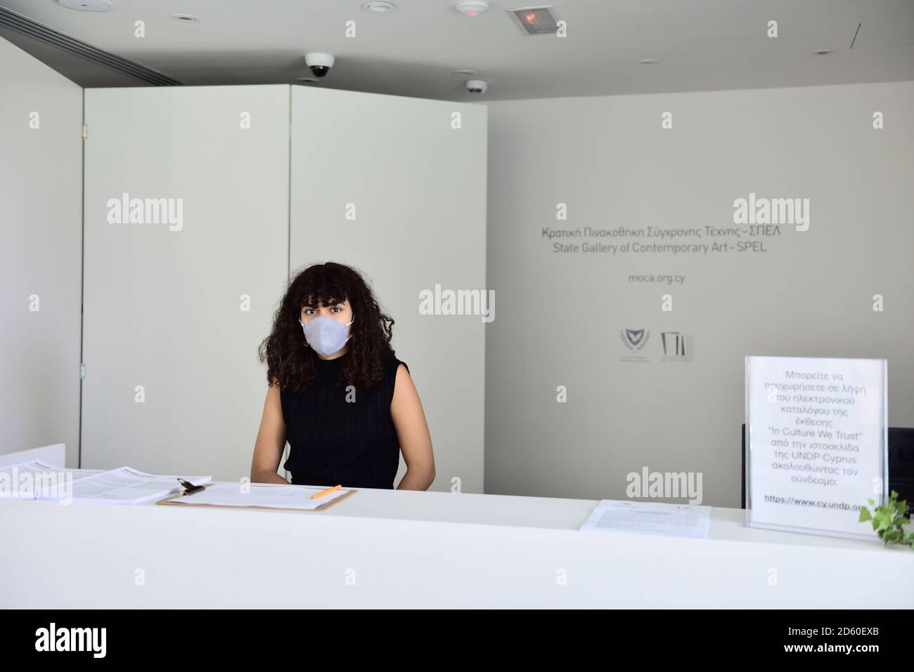 Young woman wearing face mask for covid precautions at reception desk