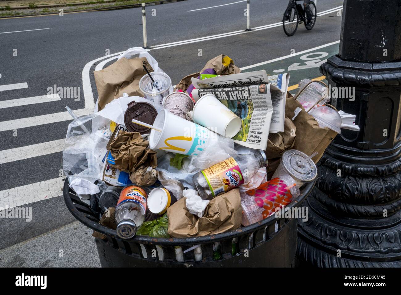 Overflowing trash can on Cortelyou Road in Brooklyn, New York. One time use containers creates the huge amounts of garbage around the US and more and more around the world. Stock Photo