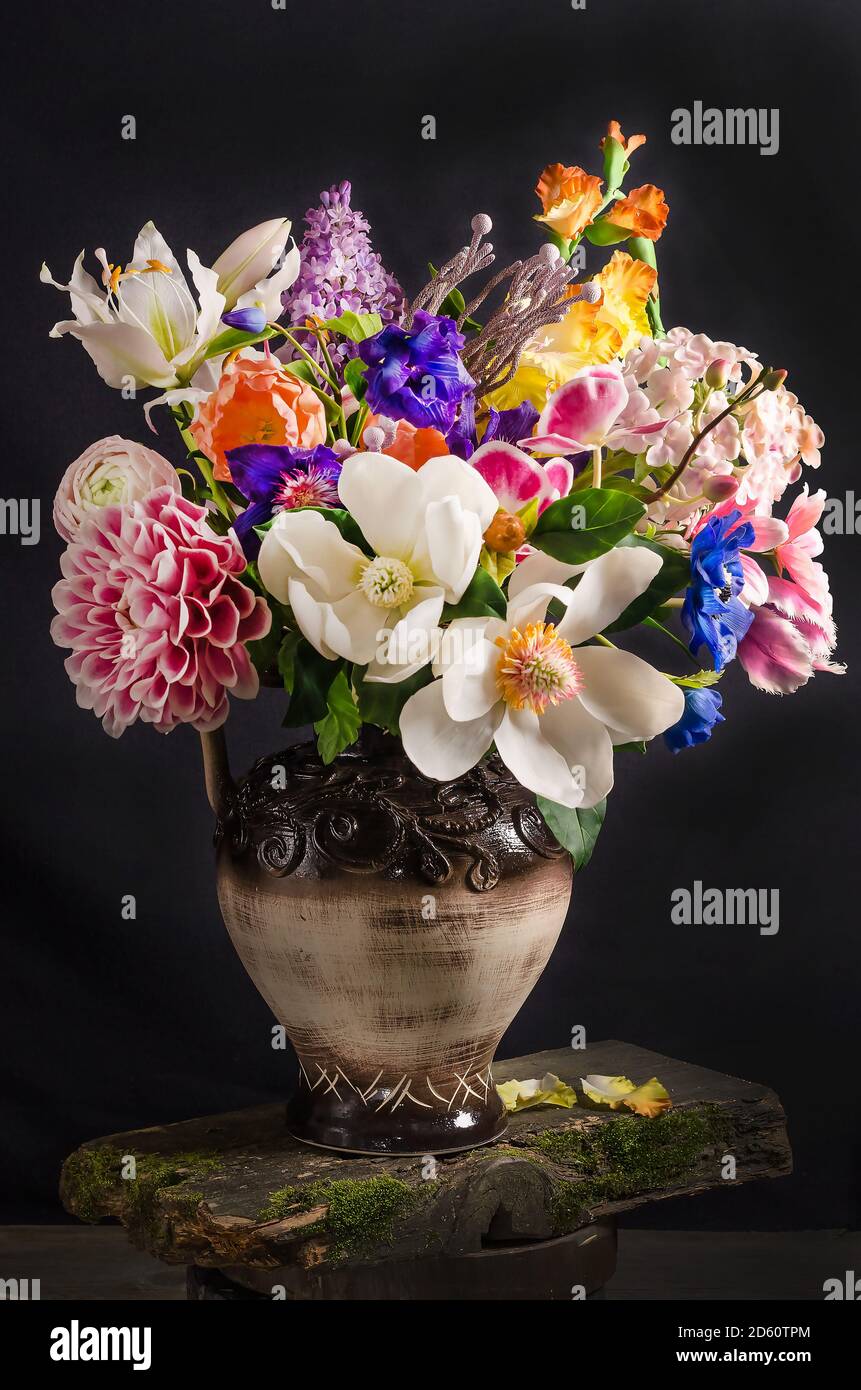 Elegant bouquet of flowers in a vase on a black background in dark ...