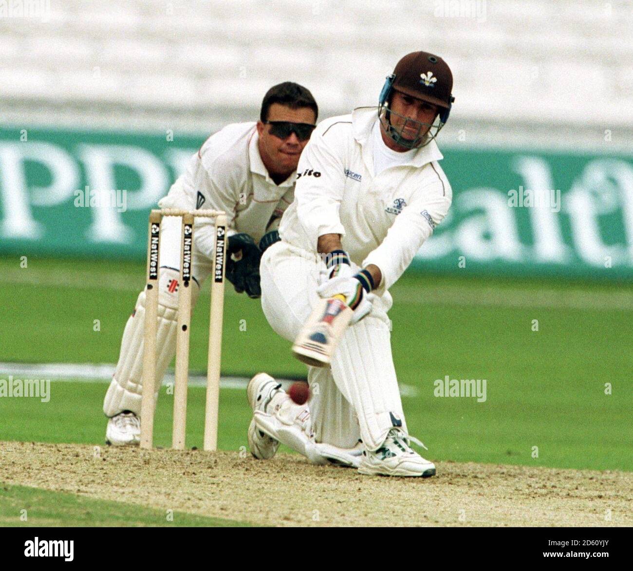 Surrey's Graham Thorpe (r) tries to sweep a ball from Lancashire's Gary Keedy  Stock Photo