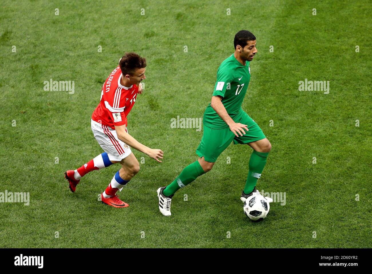 Russia's Aleksandr Golovin (left) and Saudi Arabia's Taisir Al-Jassim (right) battle for the ball Stock Photo