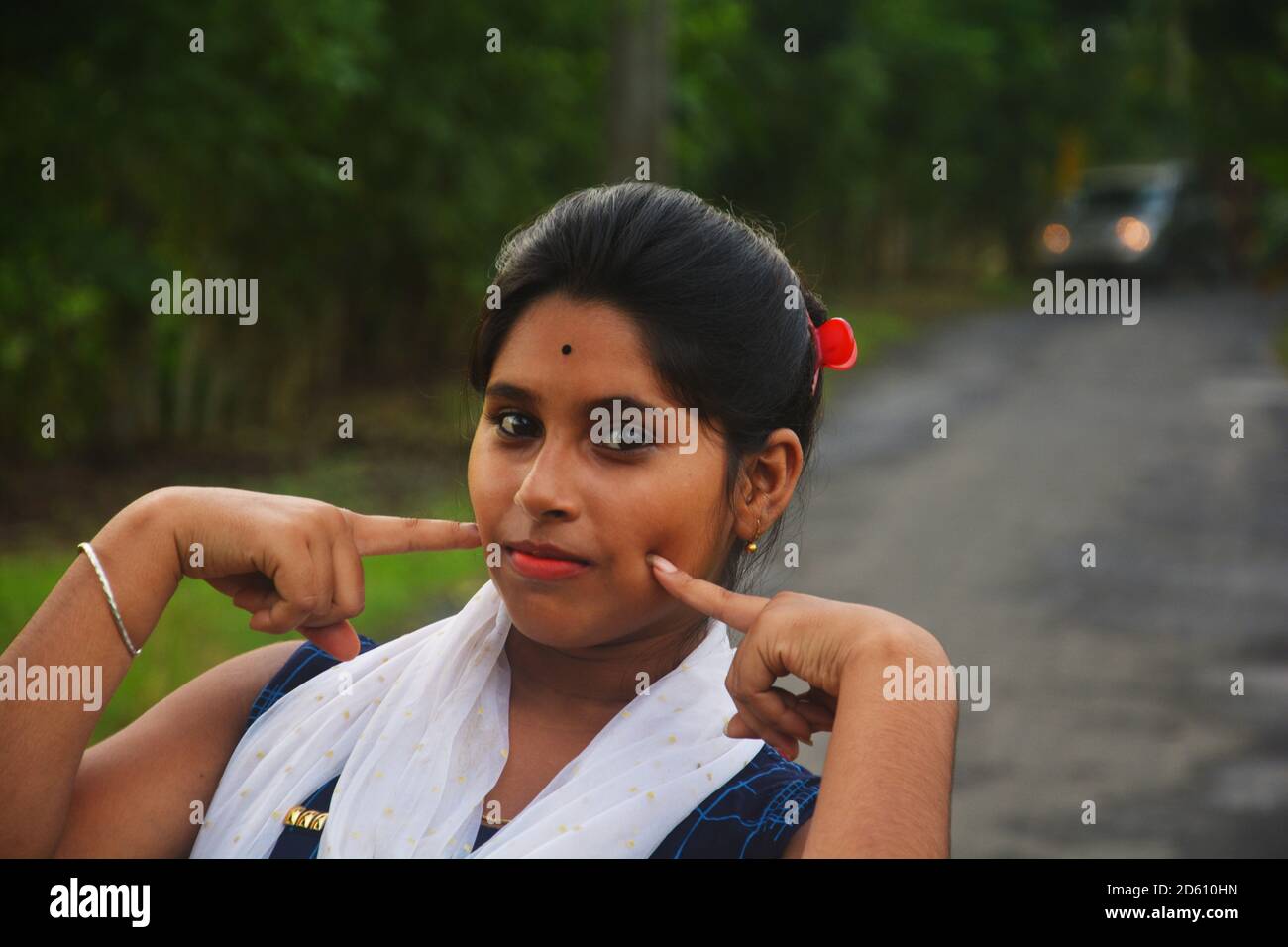 Close up of  teenage girl with her two first finger on her cheeks, selective focusing Stock Photo