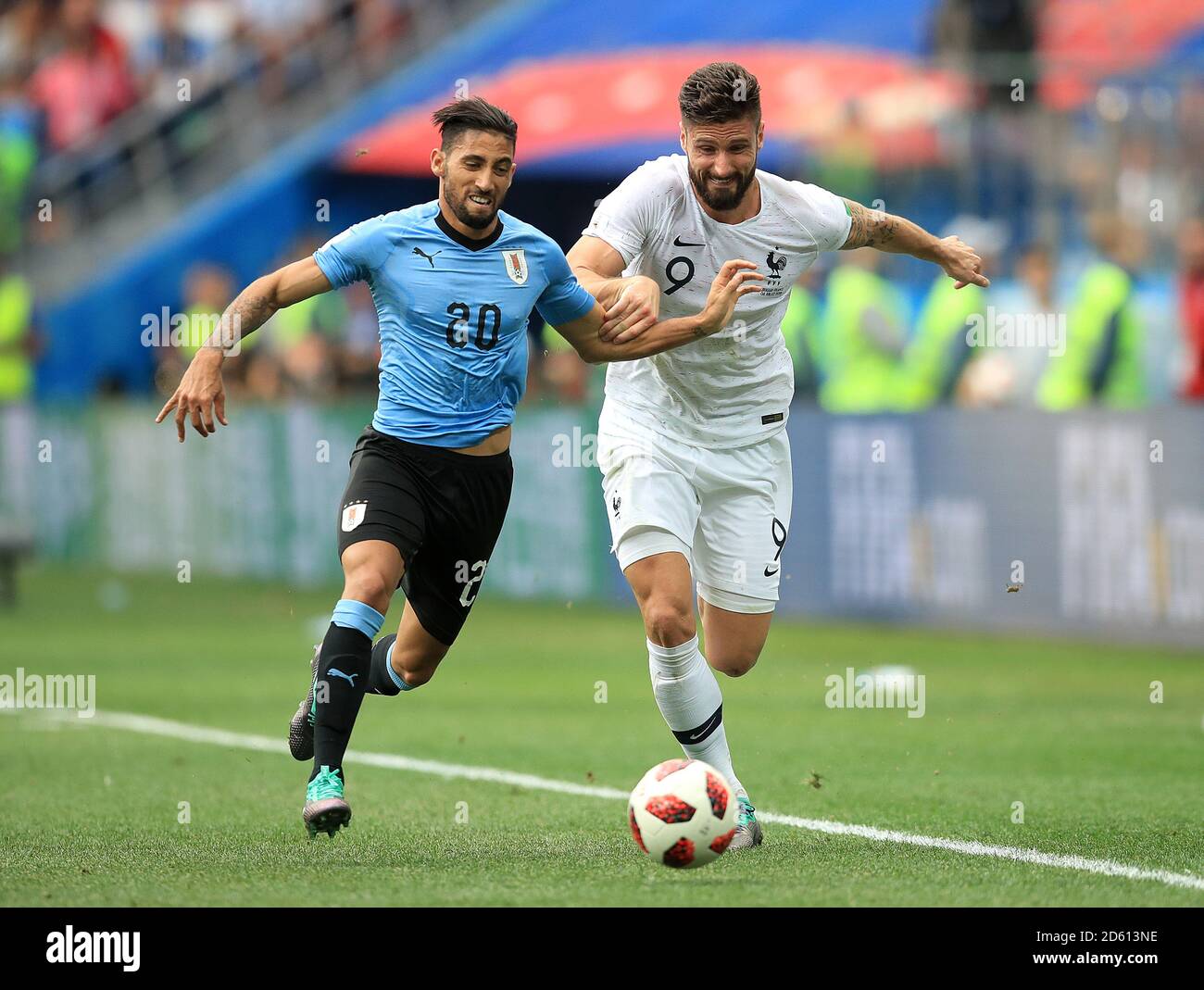 Uruguay's Jonathan Urretaviscaya (left) and France's Olivier Giroud battle for the ball Stock Photo