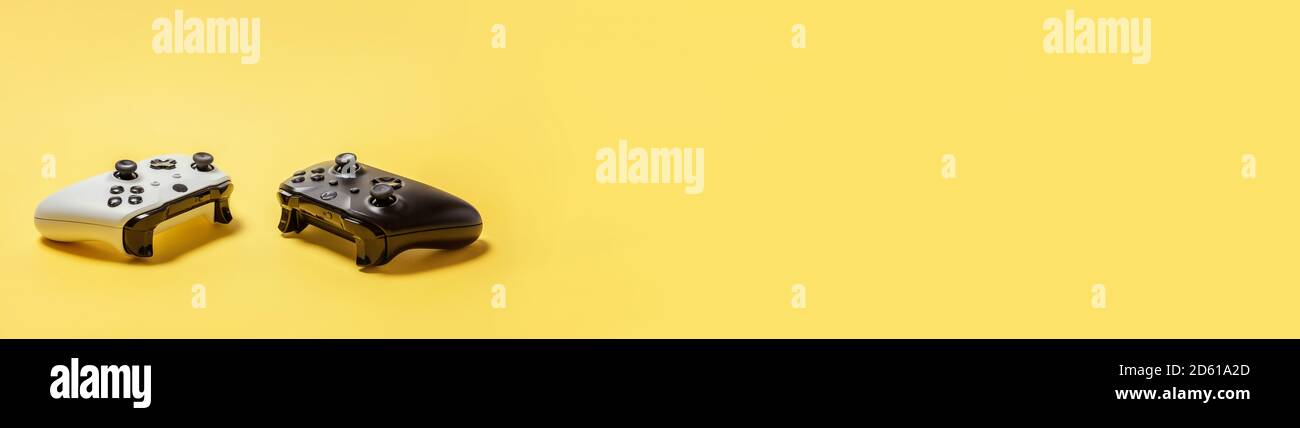 White and black two joystick gamepad, game console isolated on yellow ...