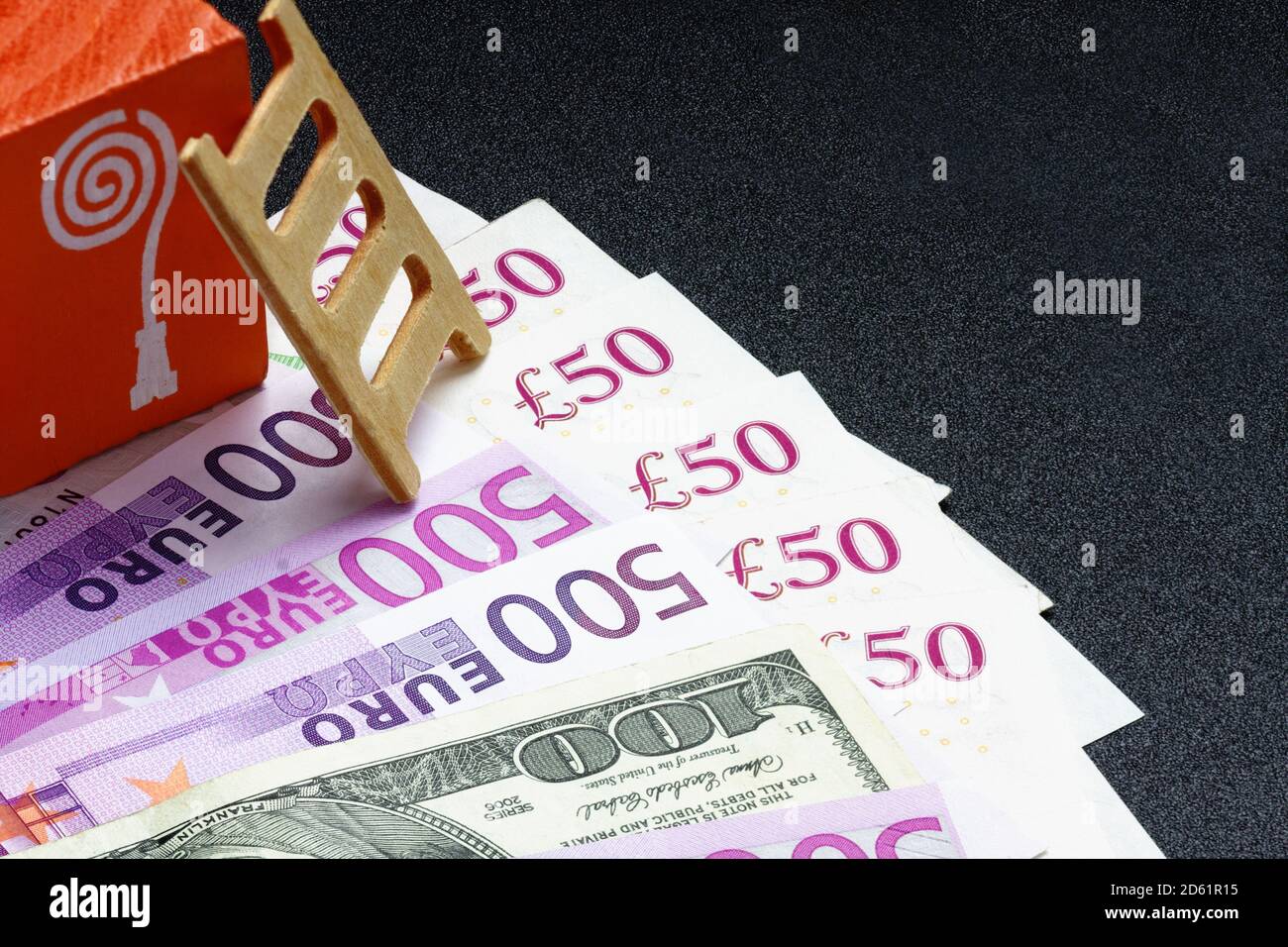The picture shows money in large bills from English, European and American, on an orange background is a twisted hose for refueling or charging wire. Stock Photo