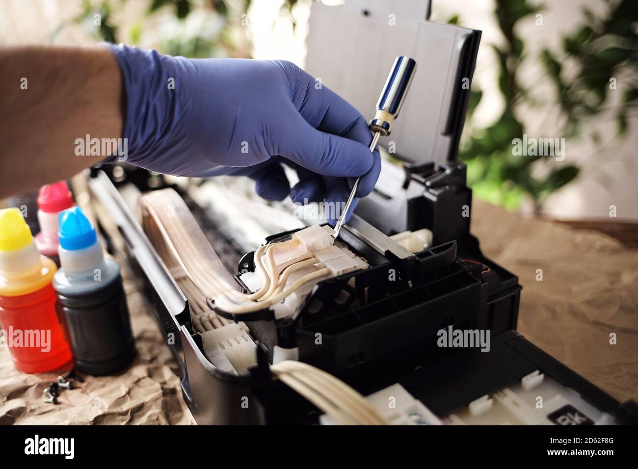 Refilling printer cartridges with multi-colored ink. Background Stock Photo