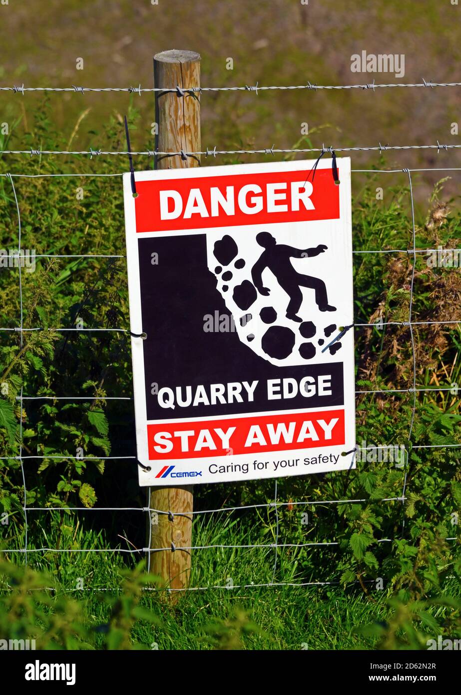 Warning sign. 'DANGER QUARRY EDGE STAY AWAY. CEMEX Caring for your safety'. Roan Edge Quarry, Cemex U.K., New Hutton, Kendal, Cumbria, England, U.K. Stock Photo
